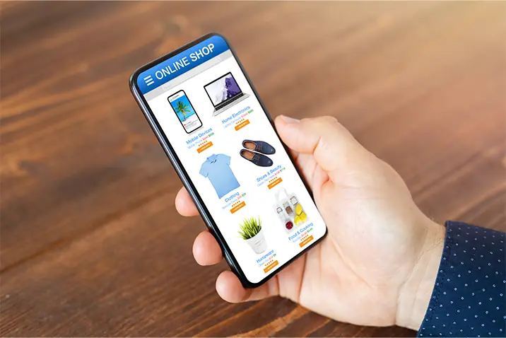 Hand hält ein Smartphone mit geöffnetem Online‑Shop und Produktübersicht